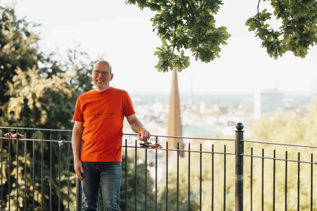 Jörn Kornfeld, Coach für Trennung, Scheidung und Beziehungskrisen, lächelt vor einer Stadtkulisse.