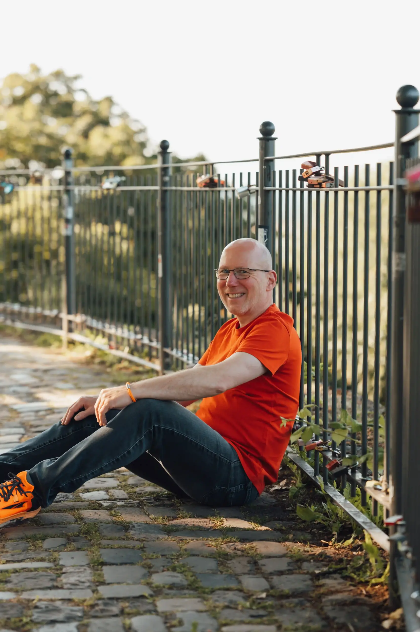 Portrait von Jörn Kornfeld, Coach für Trennung und Beziehungskrisen, im Freien sitzend und lächelnd.